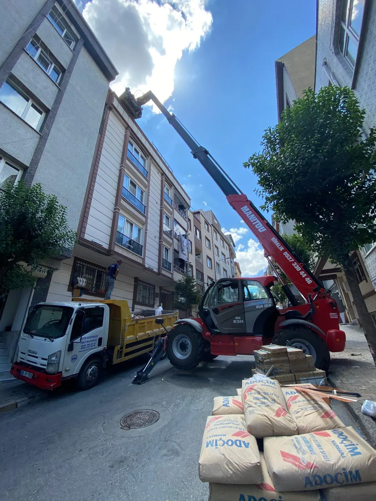 Çimento torbalarının yanında konumlanmış Manitou